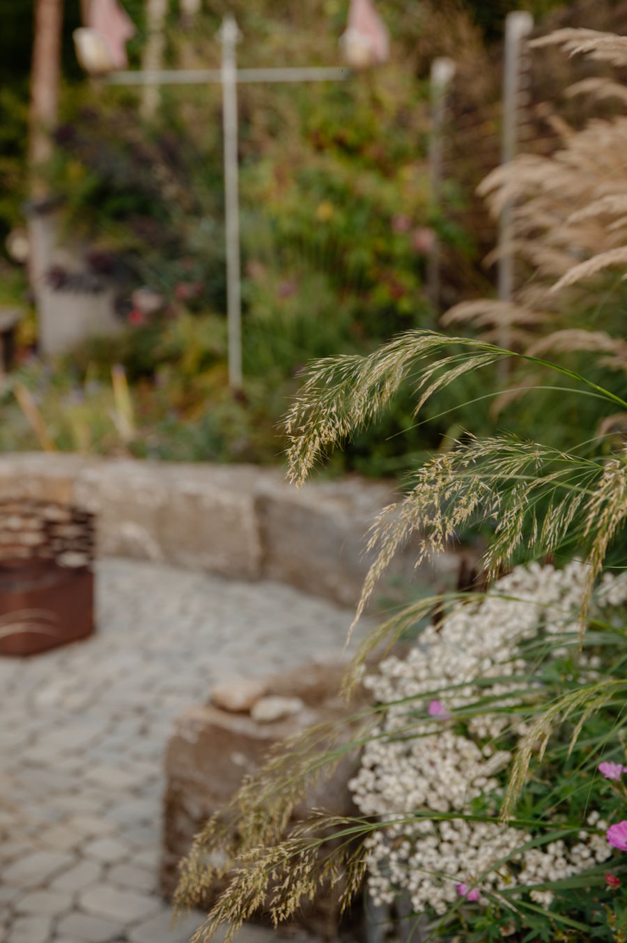 Bilderwelt Gartengestaltung - Natursteinplaster umrandet mit einer Natursteinmauer und individueller dichter Befplanzung
